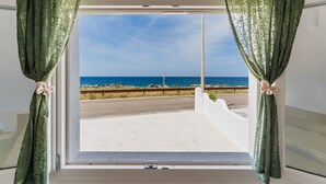 A window with green curtains, a view of the sea, and a white wall. - Villa Paradiso by Vivimy (Capilungo)