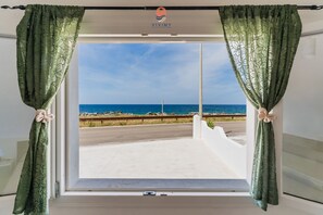 A window with green curtains, a view of the sea, and a white wall. - Villa Paradiso by Vivimy (Capilungo)