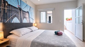 Une chambre à coucher avec un lit, une table de chevet, une lampe, une fenêtre et une porte.