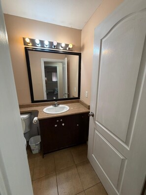 Un baño con lavamanos, espejo y tocador.