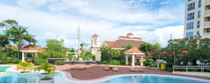 Un complexe hĂŽtelier dotĂ© dâune piscine, dâun espace extĂ©rieur amĂ©nagĂ© et dâun bĂątiment ressemblant Ă une Ă©glise, avec un clocher.