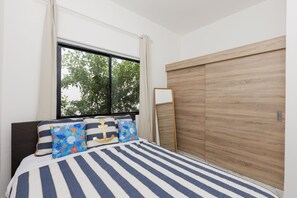 A bedroom with a bed, a window, a wardrobe, and a bedside table. - 3-bedroom house in peaceful Punta Cana with cool AC (Punta Cana)