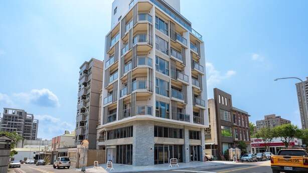 Un edificio a più piani dal design architettonico moderno, con balconi e ampie finestre.
