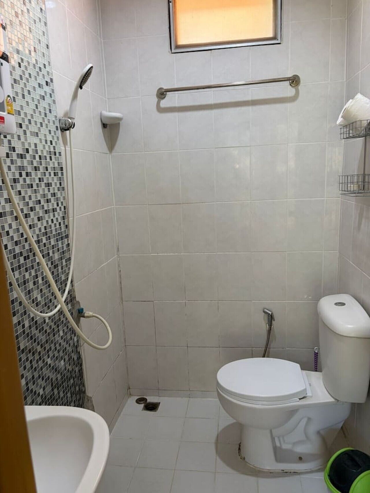 A small bathroom with a toilet, a shower, and a sink.