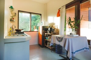 A kitchen with a sink, a table with a tablecloth, and a window with blinds. - Entire Private House 2BR - Heart of Thong Sala (Tambon Ko Pha-ngan)