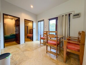 Ein Zimmer mit Bett, Stuhl, Tisch und Heizkörper.