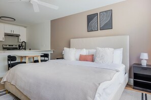 Ein Hotelzimmer mit Bett, Nachttisch und einer Küchenzeile.