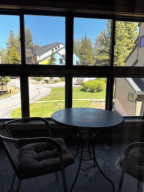 A room with a large window, a round table, and two chairs. - Walk to Eagle Lodge from this Cozy 2 Bedroom Condo (Mammoth Lakes)