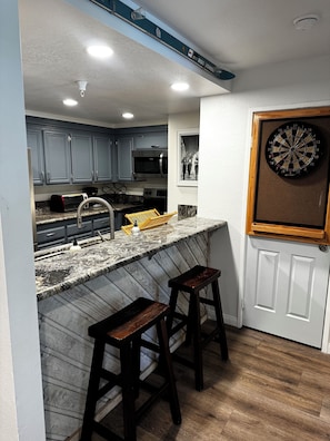 A kitchen with a microwave, toaster, and bar stools. - Walk to Eagle Lodge from this Cozy 2 Bedroom Condo (Mammoth Lakes)