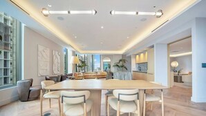 A modern interior with a large dining table, chairs, and a kitchen area. - The YORK suite Miami downtown (Miami)