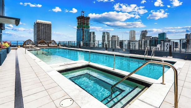 A rooftop pool with a city skyline view, including high-rise buildings and a construction crane. - The YORK suite Miami downtown (Miami)