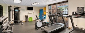 Et fitnesscenter med løbebånd, styrkemaskiner og træningsbolde.