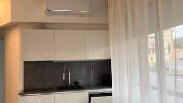 Een koelkast, een oven, een vaatwasser, kookgerei, borden en bestek