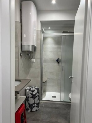 Une salle de bain moderne équipée d’une douche, de toilettes et d’un lavabo.