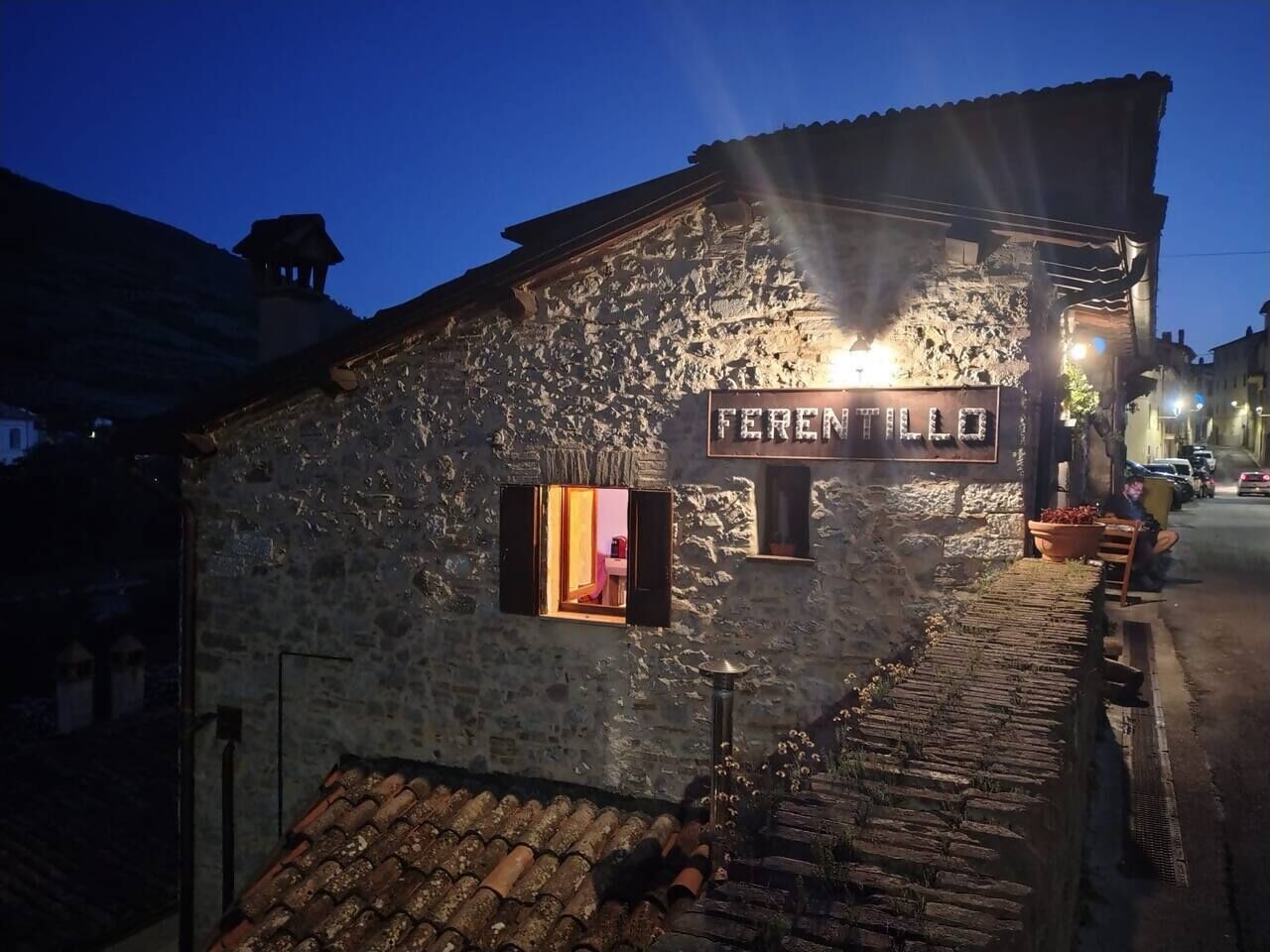 A stone building with a sign reading 'FERENTILLO' and a lit window.