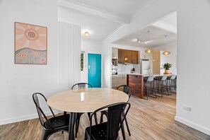 Een moderne keuken met houten kastjes, een centraal eiland en barstoelen.