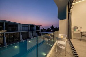A modern building with a glass balcony overlooking a swimming pool. - Comfy Townhouse Near Fisherman (Bophut)