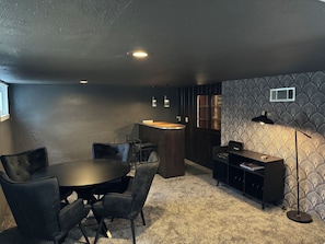 A room with a round table, chairs, a bar area, and a patterned wall. - 3BR Family and Pet-Friendly College Hill Home • Walk to Wesley (Wichita)