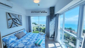 Une chambre Ă coucher avec un lit, une grande fenĂȘtre et une vue sur la mer.