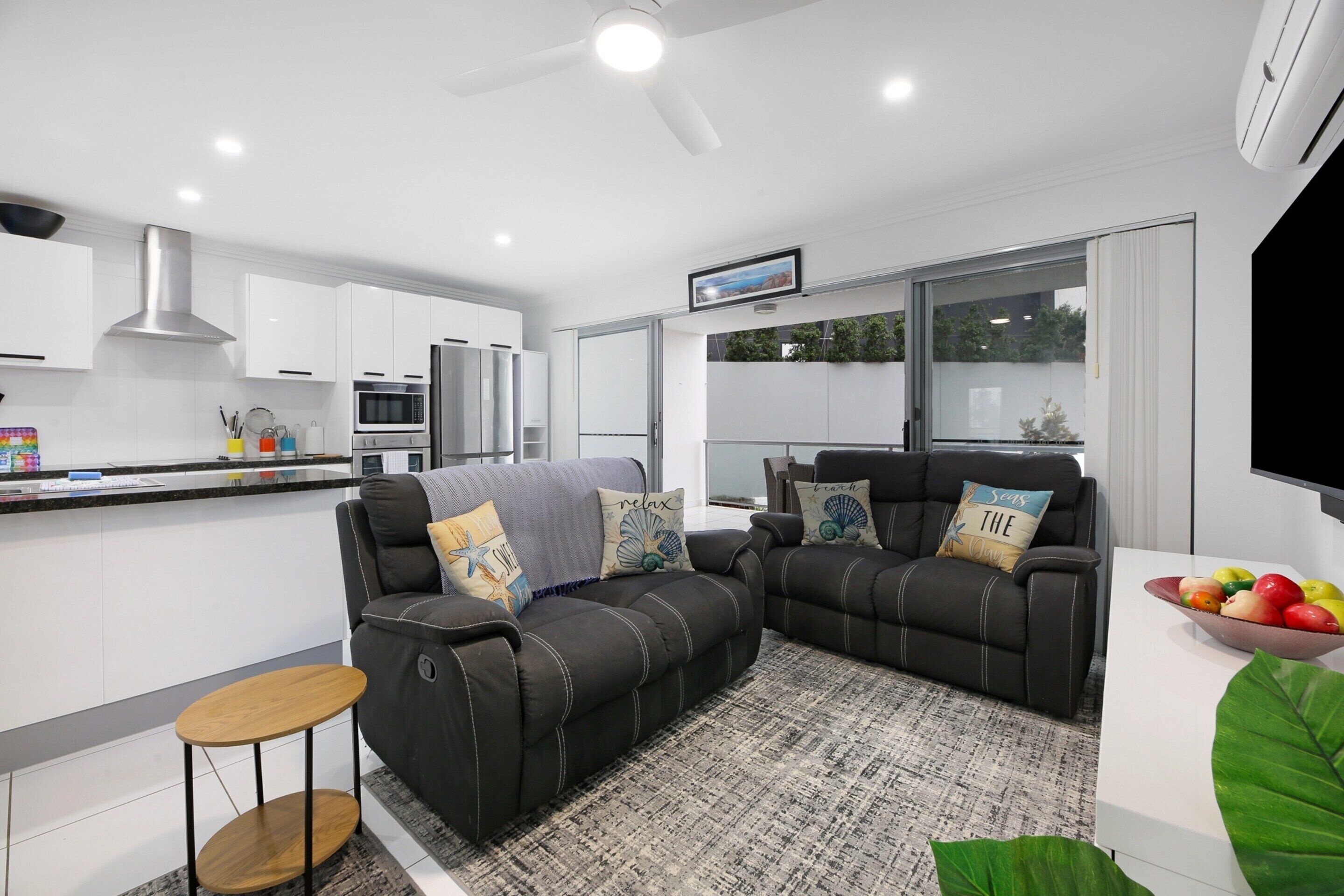 A modern living room with a sofa, a coffee table, and a TV.