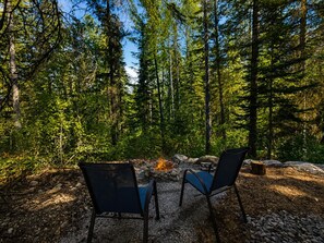 Un espace boisé avec un foyer et deux chaises.