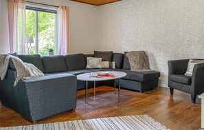 A living room with a sectional sofa, a round coffee table, and a patterned rug. - 4 bedroom amazing home in Villshärad (Villshärad)