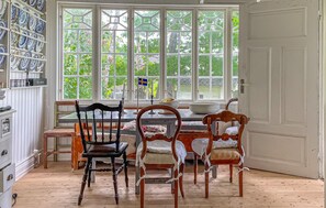 A dining area with a large window, a table, and four chairs. - 3 bedroom amazing home in Långås (Långås)