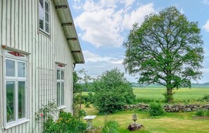 Ein weißes Gebäude mit vielen Fenstern und einer Steinwand im Vordergrund.