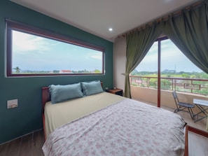 A bedroom with a bed, a nightstand, a window, and a view of the outdoors. - Art Rice field Y Van Cac Homestay  (Hoa Lu)