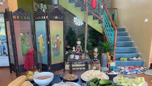 Una mesa de comedor con diversos platos, una escalera y decoraciones tradicionales.