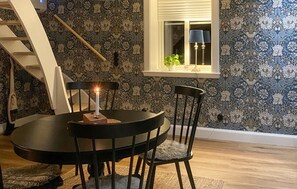 A dining area with a round table, chairs, a candle, and a window with a plant. - 2 bedroom amazing home in Vaggeryd (Vaggeryd)
