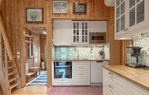 A wooden interior with a kitchen area featuring cabinets, a microwave, and a sink. - Lovely apartment in Sälen with sauna (Sälen)