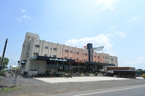 A multi-story building with a flat facade, large windows, and a sign indicating it is a hotel.