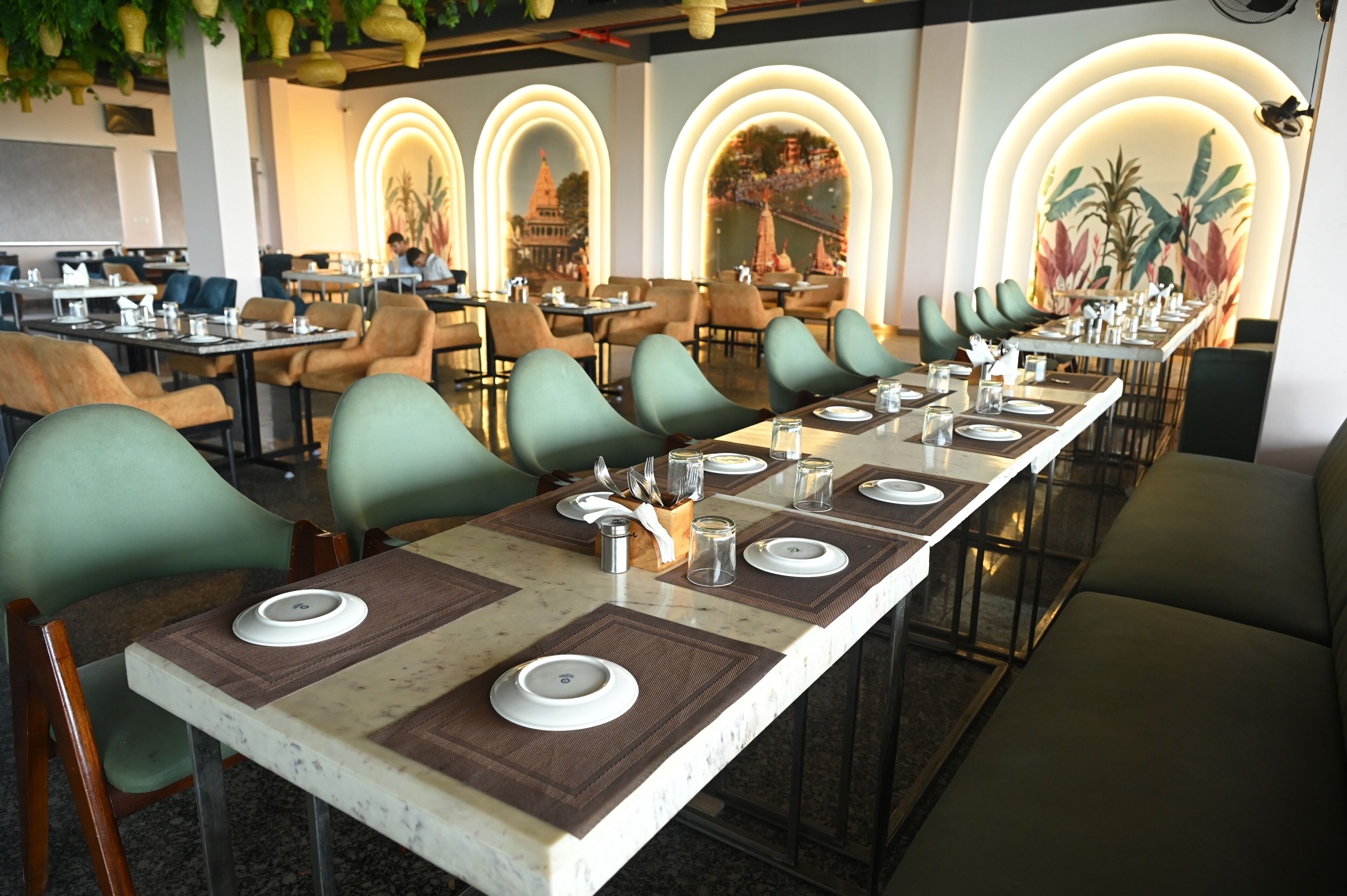 A restaurant with a long dining table set for a meal, surrounded by chairs.