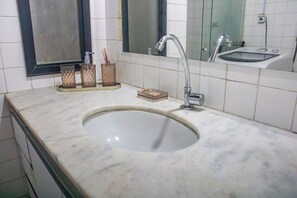 Un bagno con lavandino, specchio e cabina doccia in vetro.