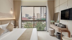 Une chambre d’hôtel avec un grand lit, un bureau, une télévision et une vue sur la ville.