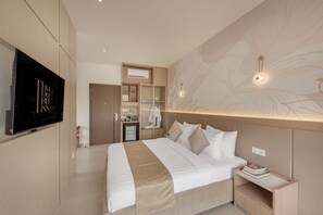 A modern hotel room with a large bed, a TV mounted on the wall, and a minibar. - Thadatra Inn (Phnom Penh)