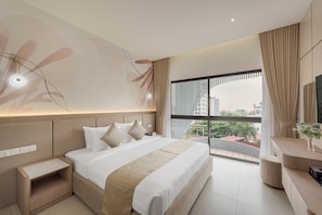 A modern hotel room with a large bed, bedside tables, a desk, and a view of the city. - Thadatra Inn (Phnom Penh)