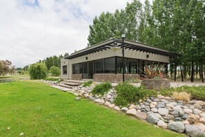 A modern house with a stone facade, large windows, and a covered patio area. - MOT Tupungato Entrevides (Tupungato)