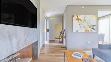 A modern living room with a fireplace, a large abstract painting, and a sofa.