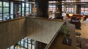 A spacious indoor area with a mezzanine level, large windows, and a variety of seating arrangements. - Skyline 2-bed Near Crown With Pool and Sauna (Melbourne)