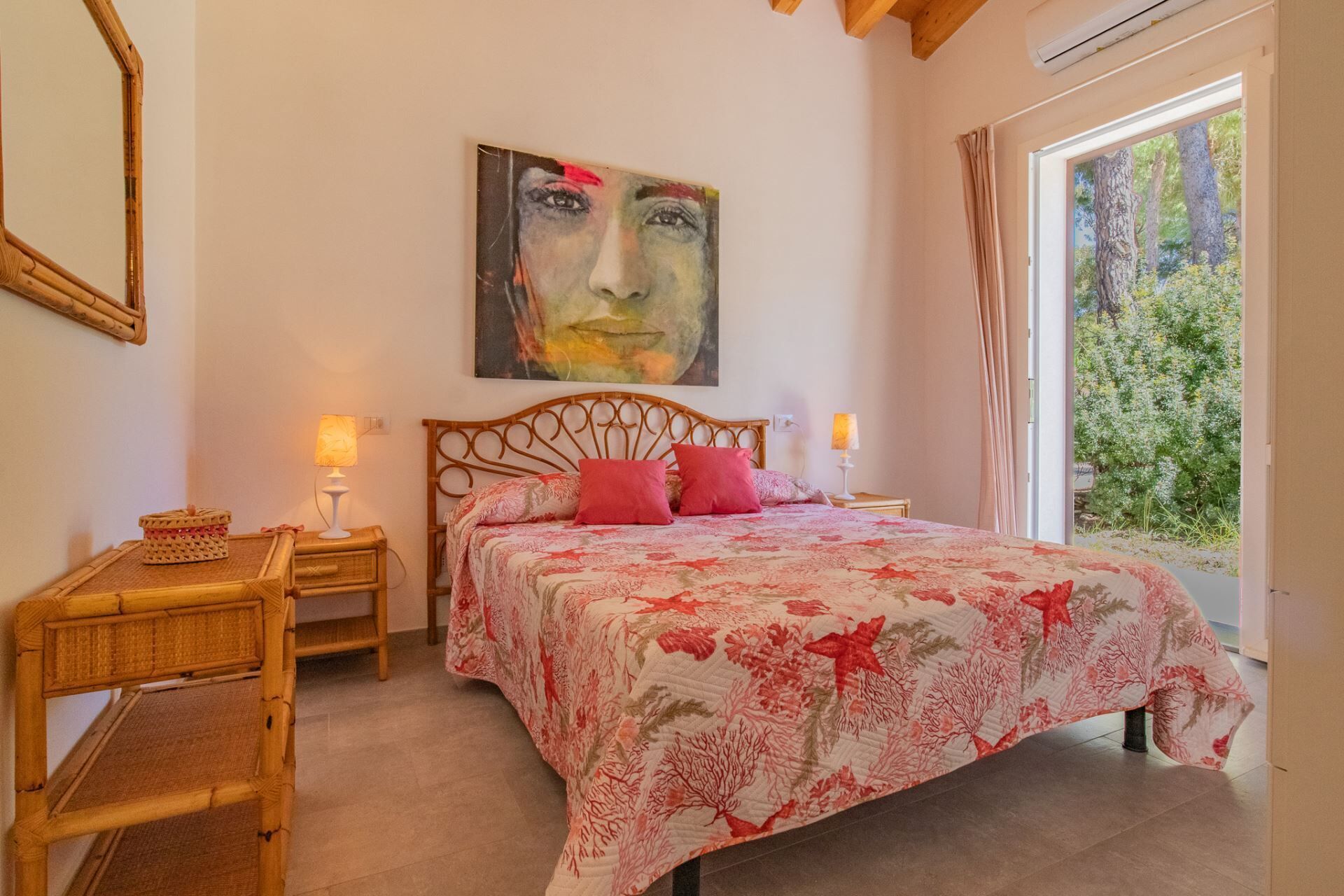 A bedroom with a bed, two bedside tables, a wall-mounted painting, and a window with curtains.