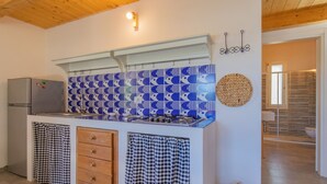 Una cocina con salpicadero estampado, un refrigerador, una estufa y un lavabo.