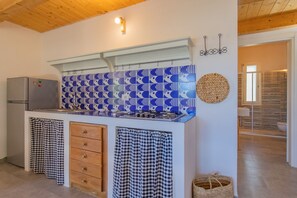 Eine Küche mit einem gemusterten Rückwand, einem Kühlschrank, einem Herd und einem Spülbecken.