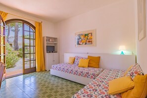 A bedroom with a sofa bed, a TV, a painting, and a lamp. - Villa Valentina - Villa Valentina 2 (Capoliveri)