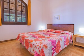 A bedroom with a bed, two bedside tables, a window with curtains, and a wall-mounted picture. - Villa Valentina - Villa Valentina 3 (Capoliveri)