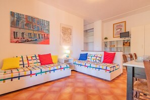 A modern living room with two sofas, a dining table, and a TV. - Villa Valentina - Villa Valentina 3 (Capoliveri)