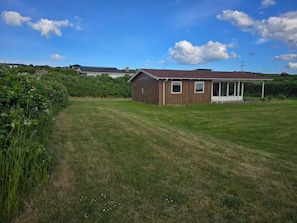 A single-story wooden building with a sloped roof, a small porch, and a clear sky. - 4 Star Holiday Home in Knebel (Skamby)