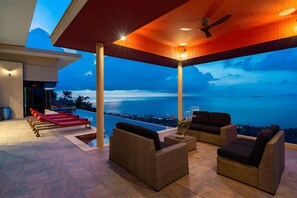 A covered outdoor seating area with wicker furniture, a pool, and a view of the ocean. - Panoramic Escape - 3BR Empress Villa (adult only) (Koh Samui)