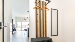 Ein Flur mit einer Bank, einem Kleiderständer und einem gerahmten Bild an der Wand.
